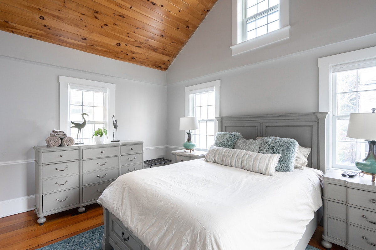 Tërhiqu në dhomën kryesore të gjumit në katin e dytë, një hapësirë e qetë dhe e rehatshme e projektuar për t 'u çlodhur sa më mirë. Kjo dhomë ftuese ka një krevat të rehatshëm me madhësi mbretëreshë me shtroja të buta, të përsosura për një gjumë të qetë pas një dite eksplorimi në Newport.