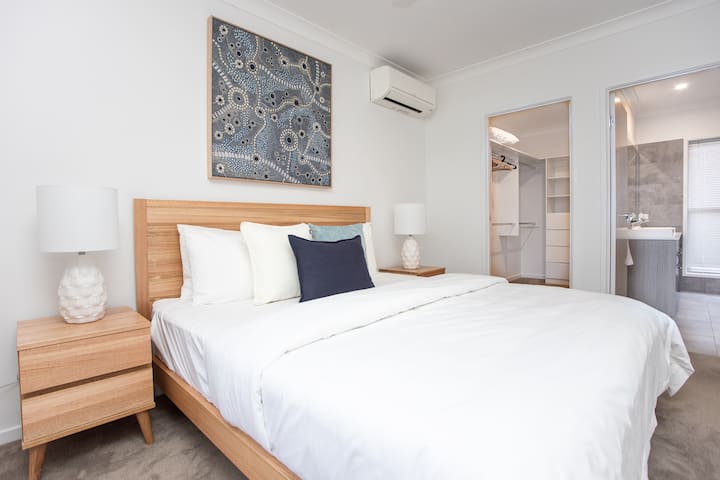 ห้องนอนใหญ่มีตู้เสื้อผ้าแบบวอล์คอินและห้องน้ำในตัวพร้อมโต๊ะเครื่องแป้งคู่และห้องอาบน้ำฝักบัวแบบวอล์กอิน