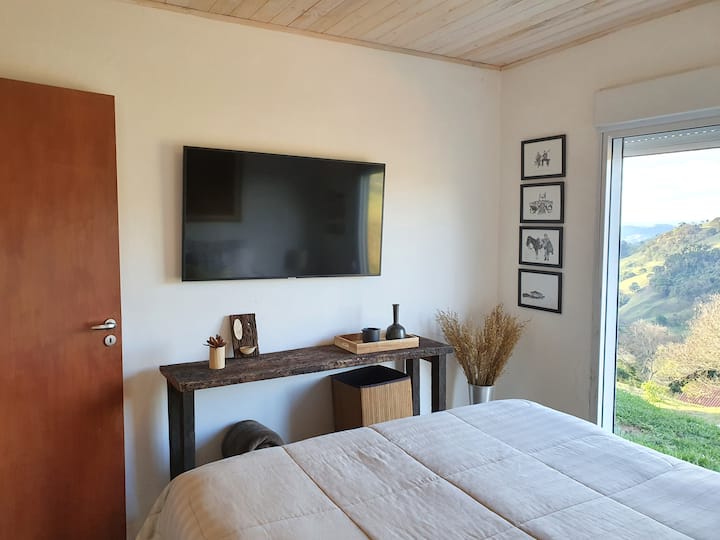 Another view of the suite with 50"TV, queen bed and view of the mountains.