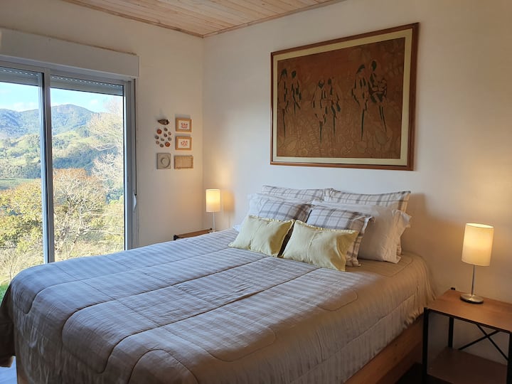 The whole house is facing the look of the mountains, the rooms as well. Here the suite with queen-size bed and the beautiful view.