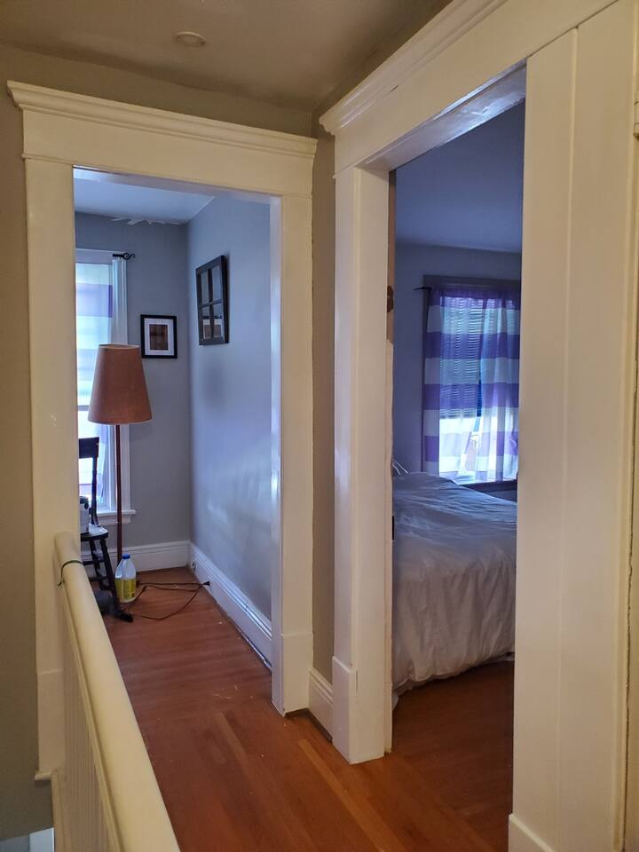 This is the hallway on the second floor leading to the kitchenette and a large bedroom.