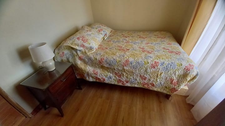Dormitorio 3 con cama de dos plazas pequeña (tamaño full de 135 cm de ancho y 190 cm de largo), guardaropa y velador.