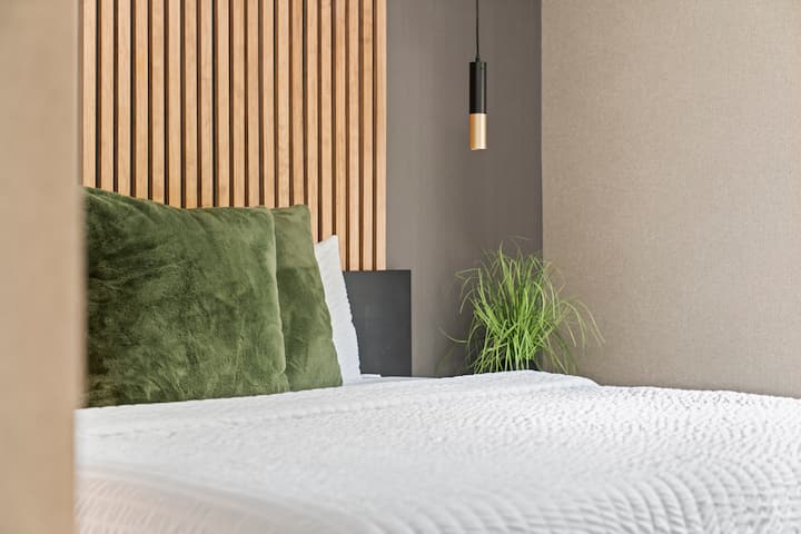 Ოთახი №4 აღჭურვილია თბილი, შეშისგან შთაგონებული დიზაინით მწვანე აქცენტებითა და ბუნების თემატიკის დეკორით, რაც ქმნის მშვიდ და მიწიერ ატმოსფეროს