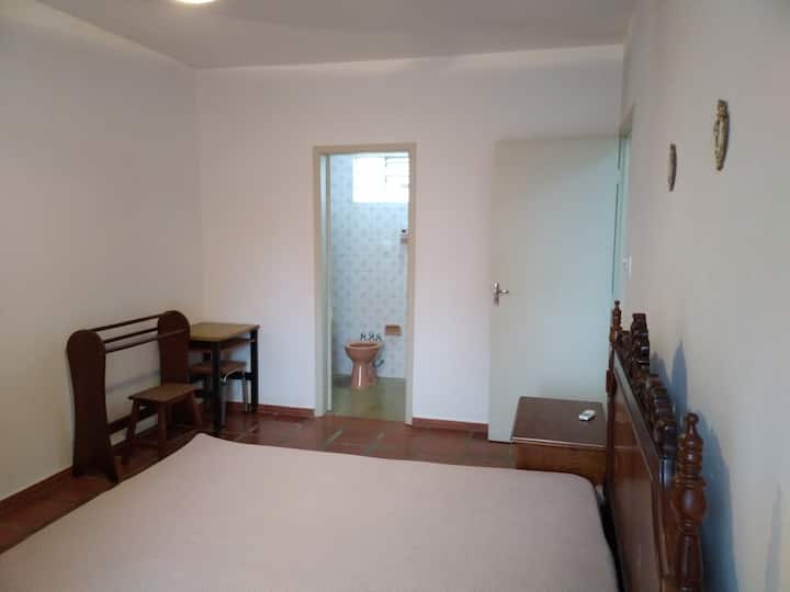 Suitë, me një tavolinë kafeje dhe stol dhe raft rrobash.