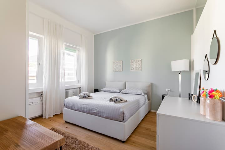 نوافذ غرفة النوم فوق أسطح المدينة والجبال في الخلفية