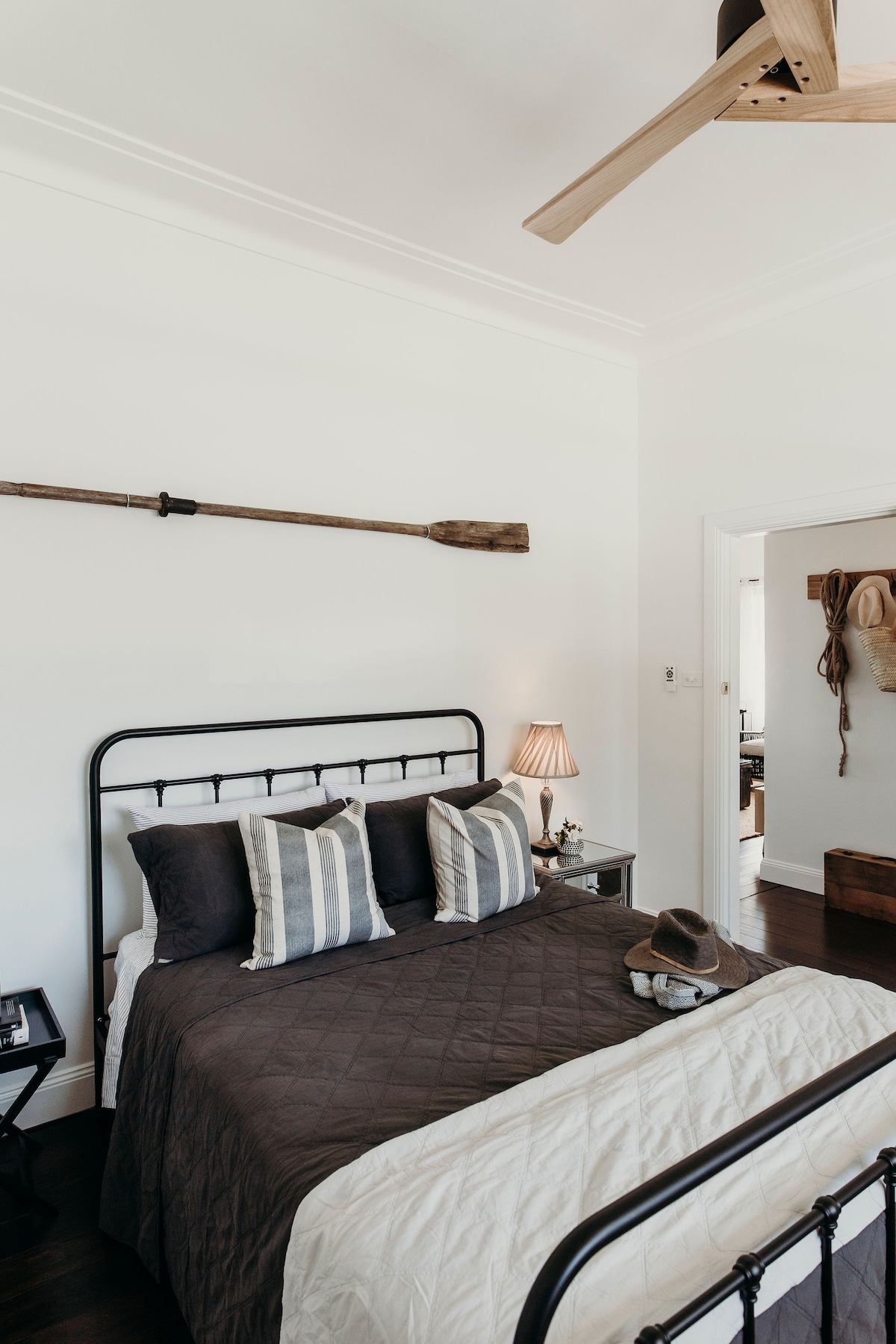 Bedroom two with queen size black iron bed, quality linen, AH Beard mattress, old ships oar and Early Settler wood ceiling fan overlooking the historic church.
