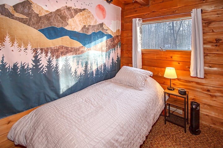 Dormitorio en la planta baja con cama individual y puerta de madera a lavadora/secadora 