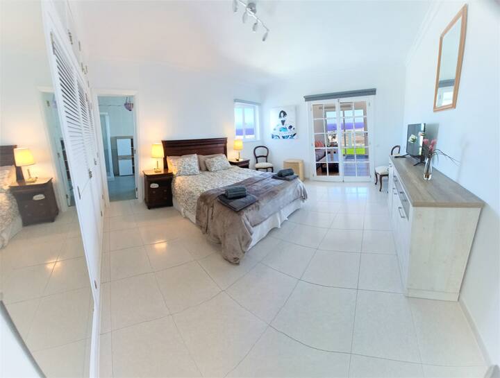 Спалня с изглед към морето, самостоятелна баня и телевизор