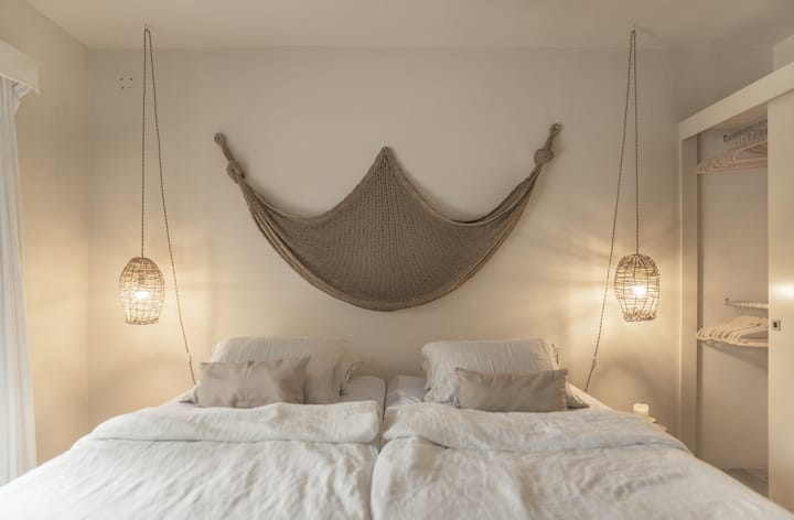 Twin bedroom glowing w/ natural light & soft neutrals.
