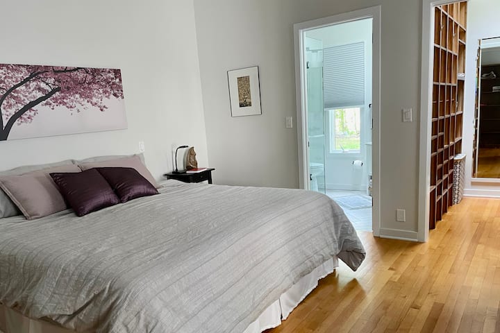 Suite en el dormitorio principal con cama tamaño king, baño principal y vestidor