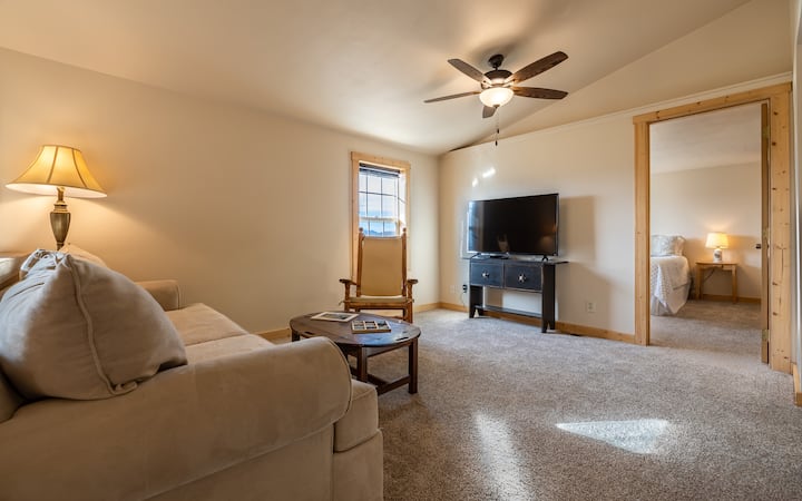 Sehemu ya juu ya sebule yenye sofa, TV na Santuri ya BluRay