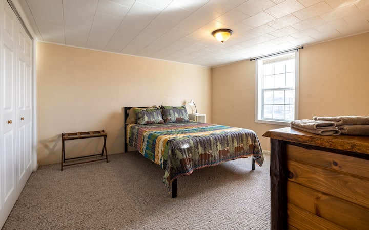 Chumba cha kulala cha ghorofa ya chini kilicho na kitanda cha malkia.