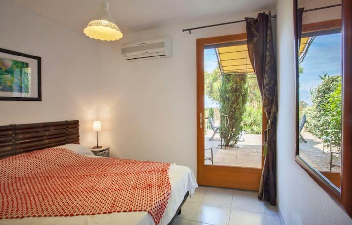 Dormitorio en la planta baja con cama de 140 cm y vista a la terraza