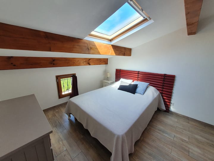 Dormitorio inclinado en la planta superior con cama de 140 cm