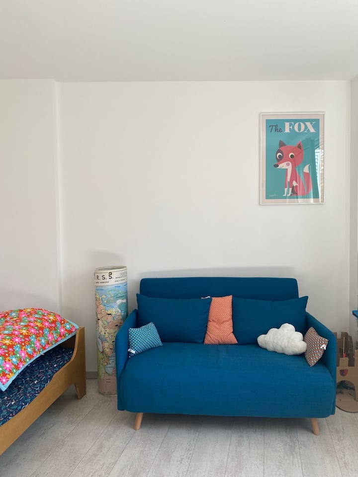 غرفة للأطفال بسرير واحد وأريكة قابلة للتحويل.