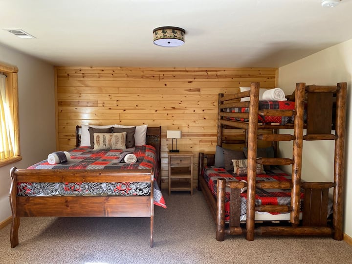 تحتوي غرفة النوم 3 الموجودة في الطابق العلوي على سرير بحجم ملكي مع مجموعة كاملة من الأسرّة بطابقين.