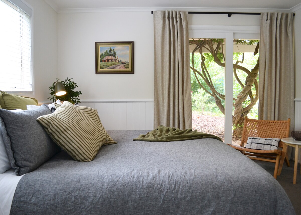 Dormitorio tamaño king con vistas a una pérgola con una glicinia impresionante