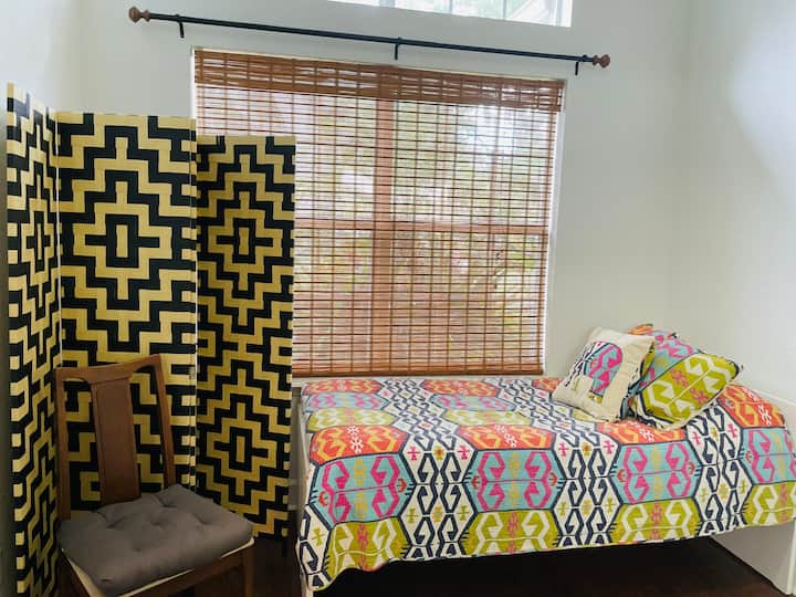 Twin daybed located in front living room. This space is not private. Doors to Queen Room 1 &2 and the shared bath are located off this area. It was previously a formal sitting room. A room screen is provided. This is not listed as a bedroom.