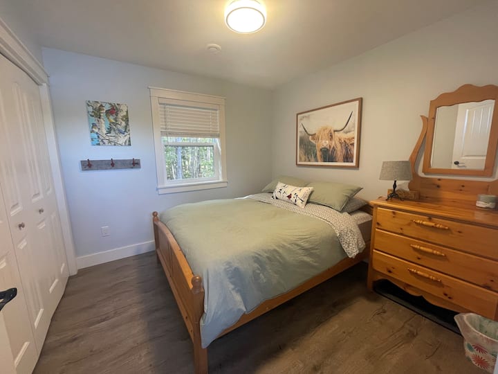 غرفة ضيوف مريحة بسرير ملكي وخزانة ملابس وخزانة ملابس.