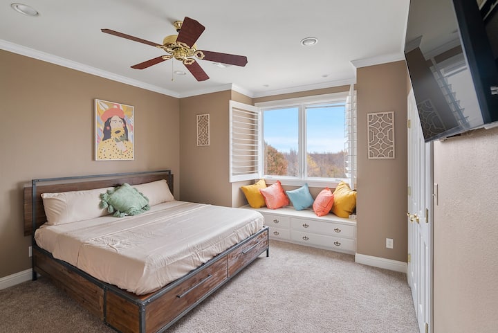 Bedroom two with a large king bed and a beautiful window seat looking over the treetops