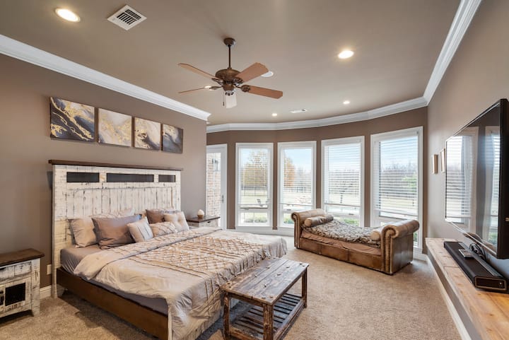 The master bedroom features a wall of windows that fill the room with light where you can lay back on the day bed overlooking the yard and get lost in a good book. 