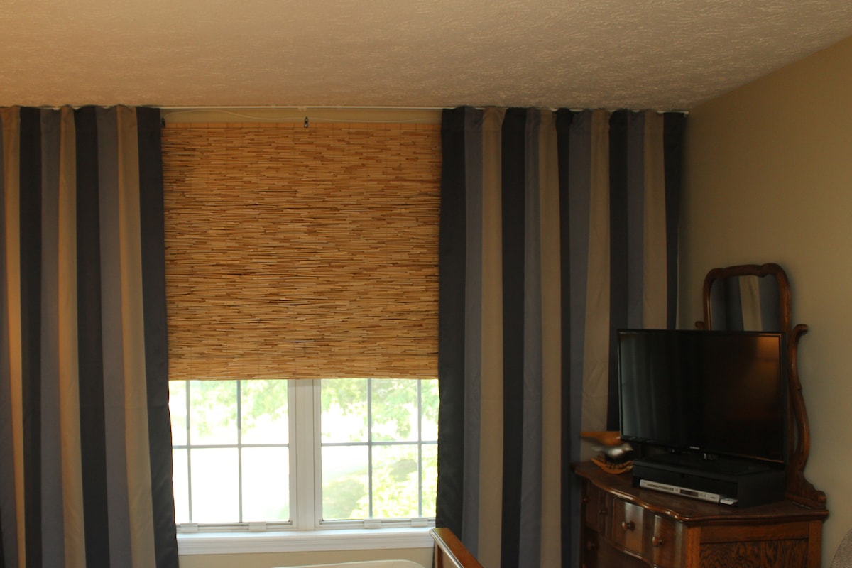 Chumba kinachoweka giza kipofu cha asali ni bora kwa wauguzi wa kusafiri ambao wanahitaji kulala wakati wa mchana. Televisheni iliyo na Roku na kifaa cha kucheza DVD iko kwenye kabati la kujipambia.