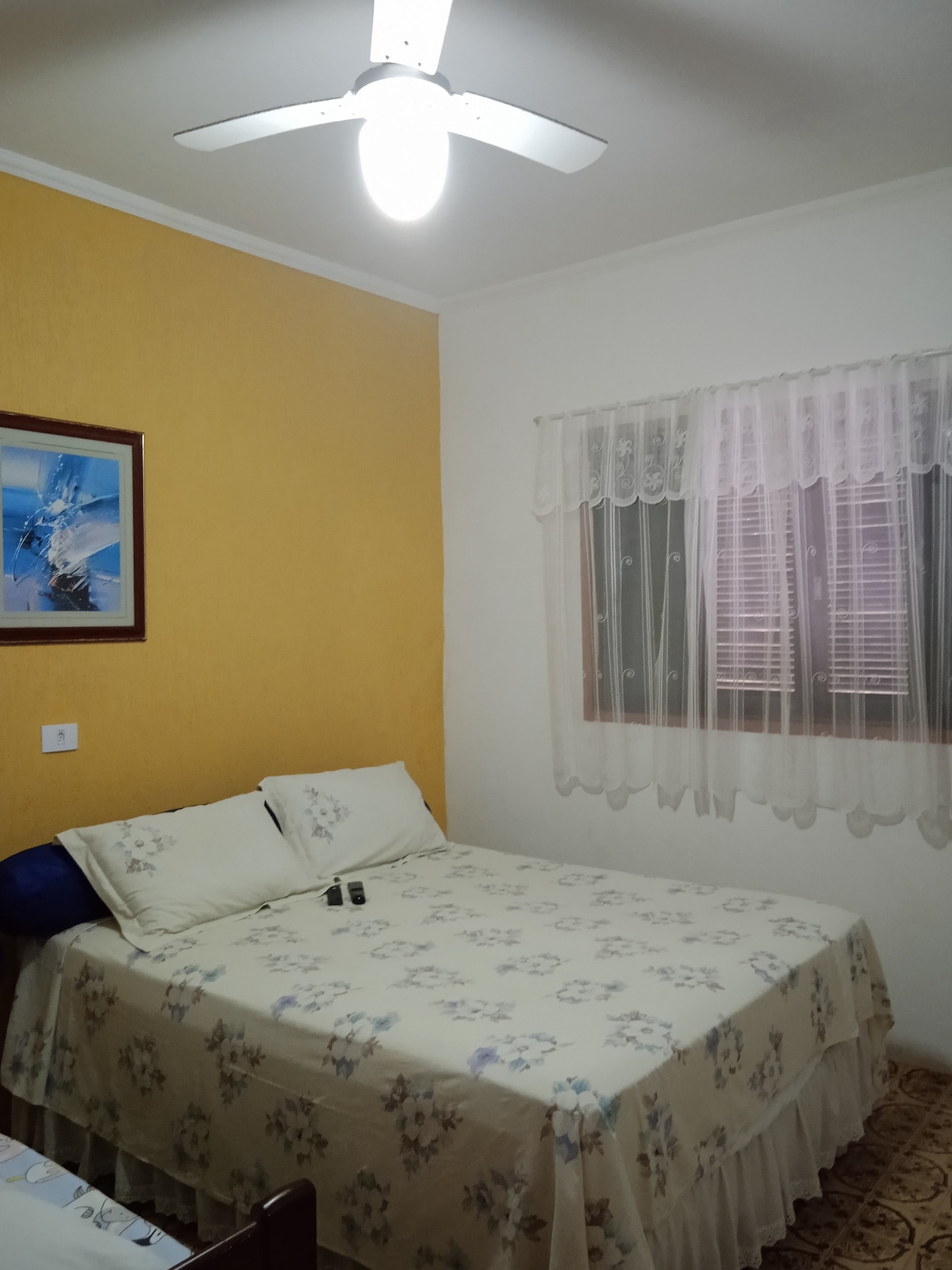 חדר ראשון עם מאוורר תקרה, מיטה זוגית, מיטה זוגית, טלוויזיה וארון. 