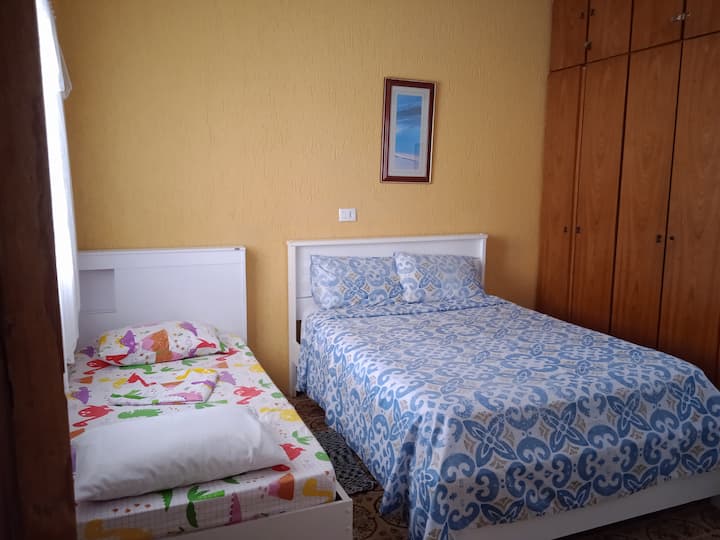 Druhá spálňa so stropným ventilátorom, manželskou posteľou a Bicamou. TV a posteľná bielizeň.