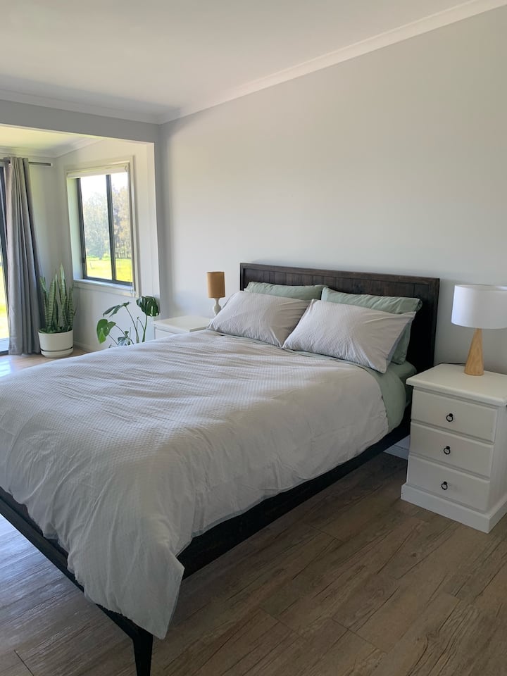 Dormitorio principal con cama tamaño queen y pequeña terraza y baño privado.
