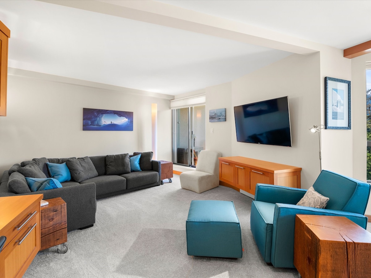 Living room with TV, chair, couch and balcony.