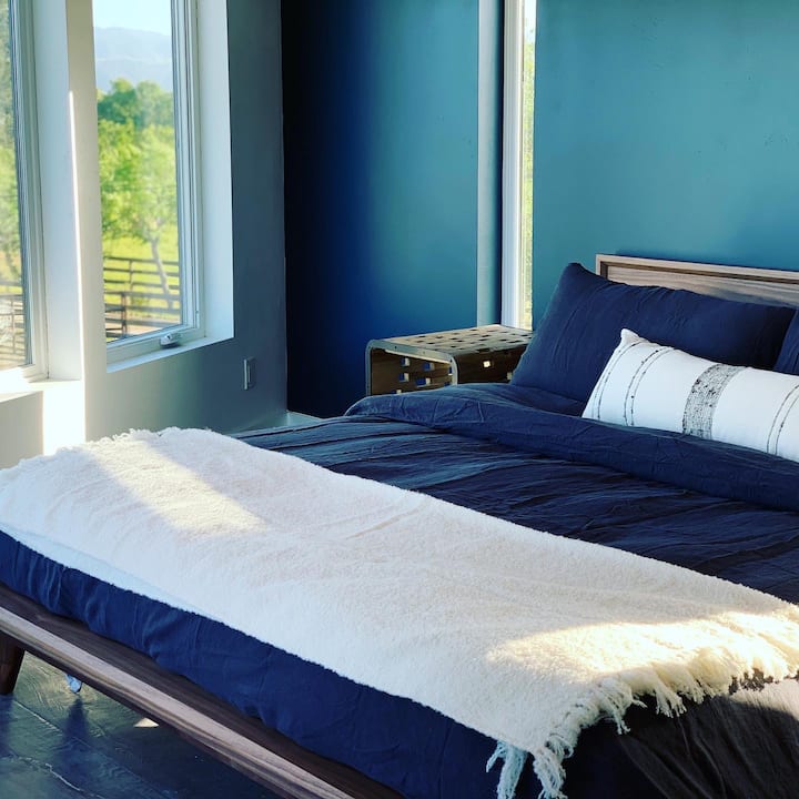 Master bedroom in Shunem retreat with closet. From the leather chair, watch the miniature longhorn bulls.  Enjoy Coyuchi all organic bedding and dry off with their towels. We wanted to spoil you with well-sourced, well made comfortable materials. 