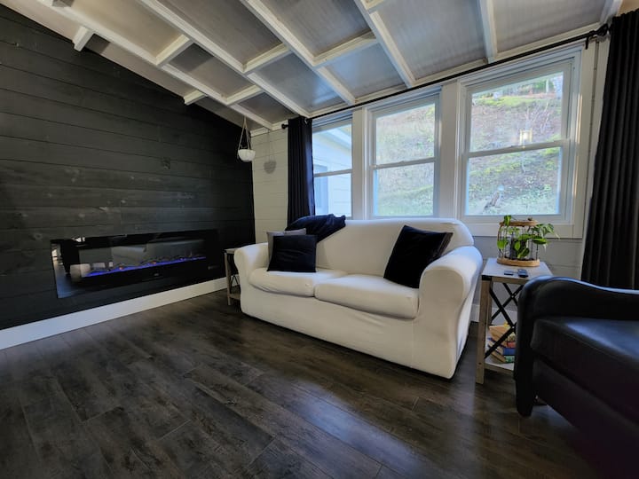 2nd 65" smart tv, electric fireplace, sleeper sofa, end tables, and leather recliner.