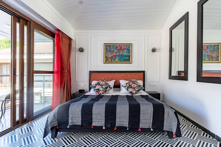 Master bedroom with high ceilings decorated in black, white and red. The king bed is perfect luxury for comfortable  sleep.