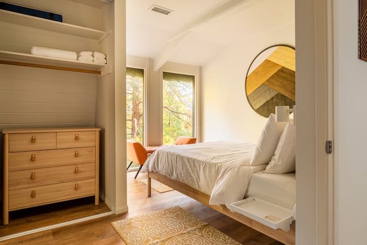 Двойната спалня предлага прозорци от пода до тавана и гледки към гората, абсолютно прекрасна гледка, до която да се събудите сутринта.