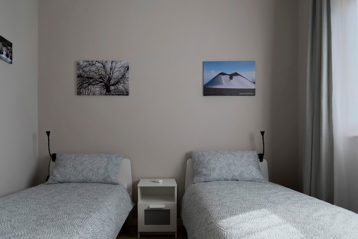 Mojawapo ya vyumba viwili vya kulala vilivyo na vitanda viwili, mapazia, kabati la nguo, televisheni mahiri, dirisha