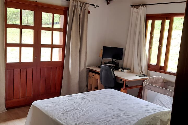 卧室配有标准双人床、儿童婴儿床和办公桌，可供工作使用