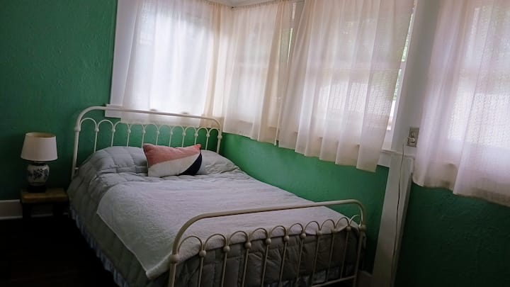 De lange achterslaapkamer was ooit een veranda en is doordrenkt met licht. Het is hier te zien met de gordijnen die zijn handgemaakt door een lokale ambachtsman. De nieuwe ramen langs de muur gaan allemaal open, om drie-seizoenenbries binnen te laten.