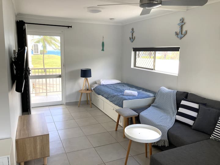 סלון עם גישה למרפסת ולנוף לים ולאיים.  מיטת יחיד בגודל מבוגר, ספה נפתחת, טלוויזיית Hisense חכמה בגודל 43אינץ '(התחברות באמצעות BYO לנטפליקס וכו ') וארון טלוויזיה.  מלתחה/ארון בגדים, מאוורר תקרה, מזגן/חימום.  תריסים ווילונות.