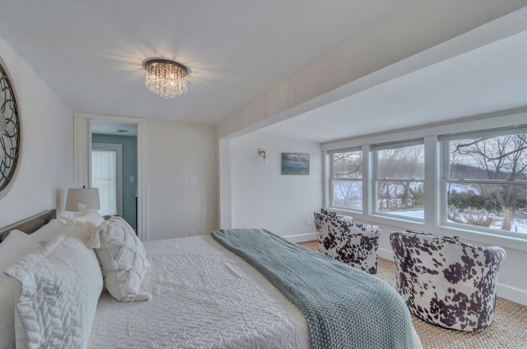 ห้องนอนใหญ่ (เตียงคิงไซส์) และพื้นที่นั่งเล่นที่มองเห็นสระว่ายน้ำและสวน