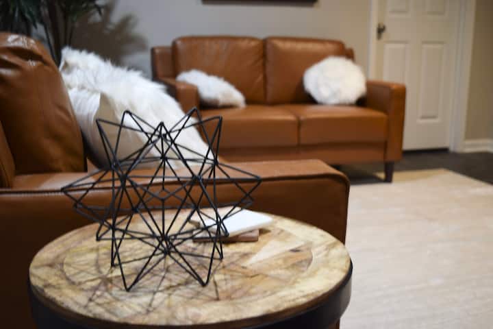 Eneo la chini ya ardhi limejaa makochi ya ngozi yenye starehe na meza za pembeni zinazofaa.