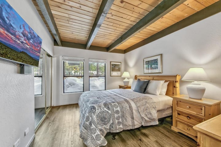 Primárna spálňa s manželskou posteľou Queen a veľkým televízorom, komodou a zrkadlovým šatníkom 