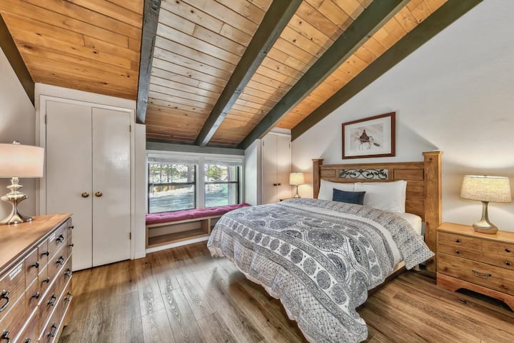 Primárna spálňa 2 s manželskou posteľou Queen, 2 komodami, okenným kútikom a klenutými stropmi.