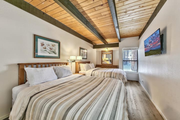 Spálňa 2 na prízemí s dvoma manželskými posteľami, televízorom, komodou a oknom