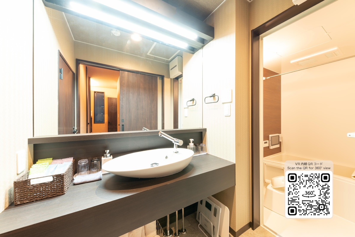 A well-lit bathroom features a modern, oval sink with a sleek faucet. Ample countertop space allows for personal items. The mirror above the sink reflects the stylish decor, while a sliding door leads to a spacious shower area. Shelving provides storage for towels and amenities.