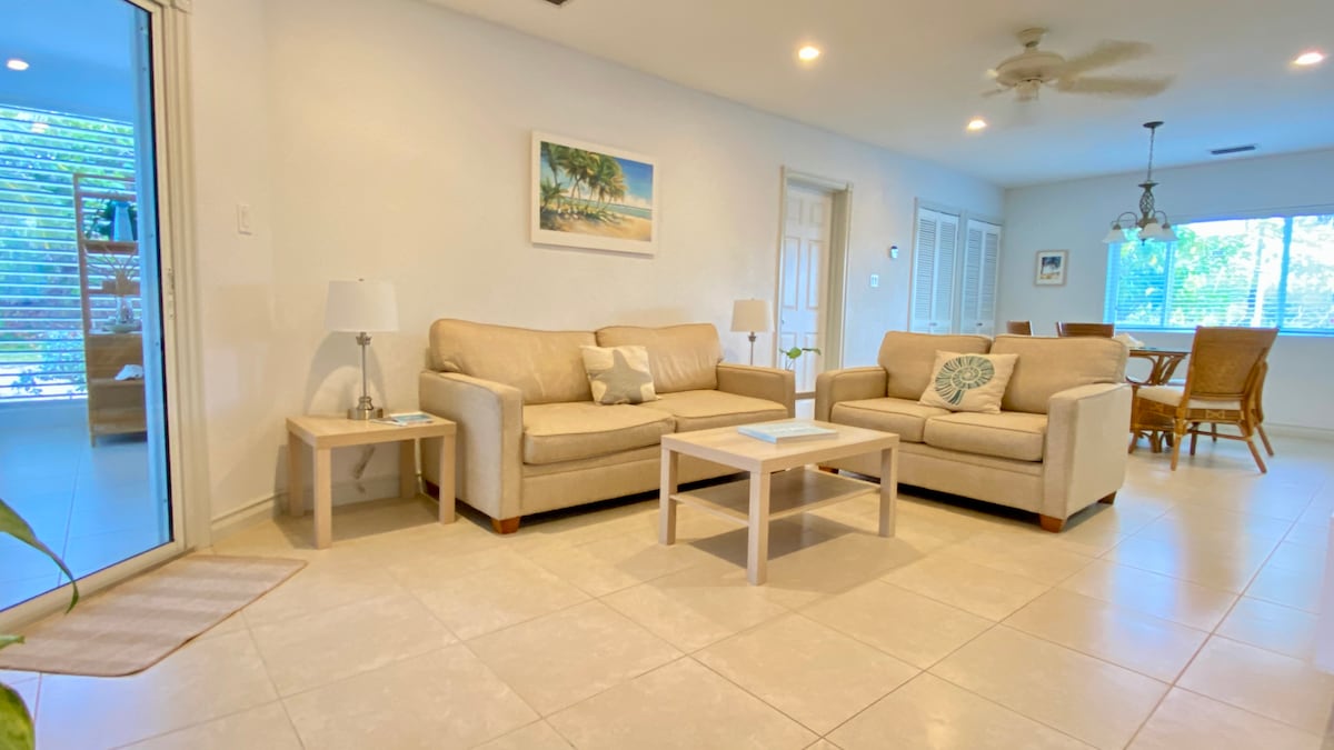 Vipengele vya sebule ni pamoja na kitanda cha sofa, sehemu ya kulia chakula na runinga bapa ya UHD Smart TV iliyo na kebo. 