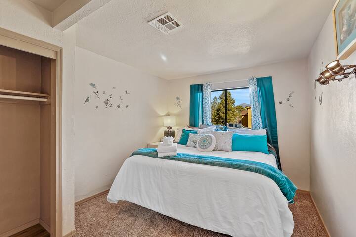 King bed in master bedroom with private Smart TV, private bathroom and closet with dresser.