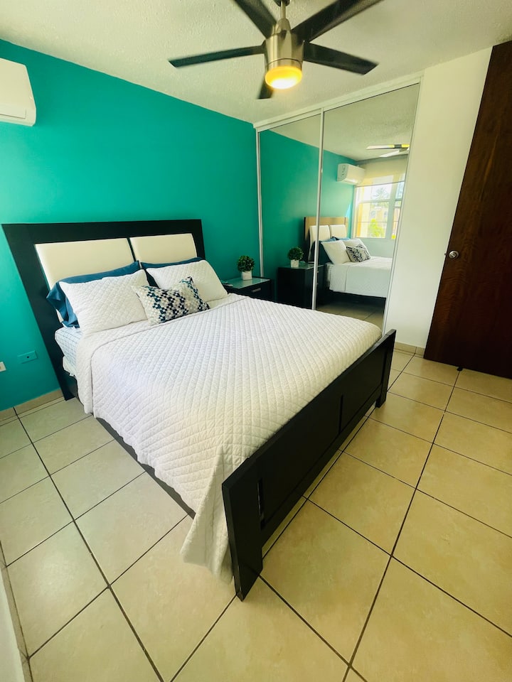 Соба со брачен кревет (широк 150-179 см), тавански вентилатор и конзола за клима уред.