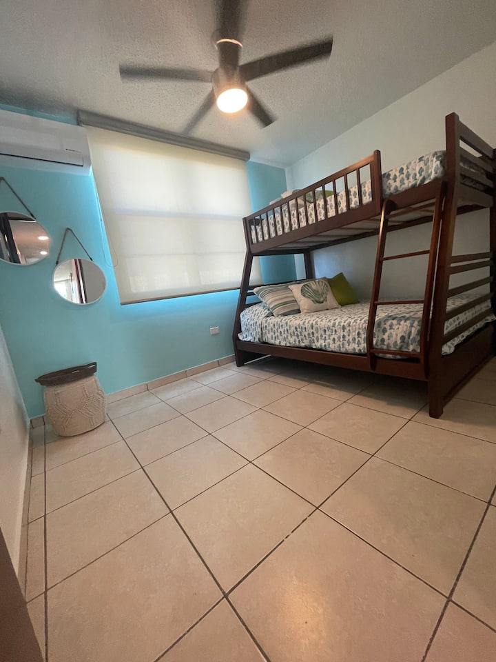 Соба со кревети на спрат, големина на брачен кревет и полн капацитет за три лица. Има тавански вентилатор и конзола за клима уред.