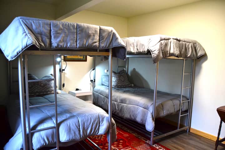 Bedroom #2- bunk beds w/foam toppers, 4- individual reading lights, oriental rug, side table w/extra outlets, & antique furniture, luggage rack, & clothing peg boards