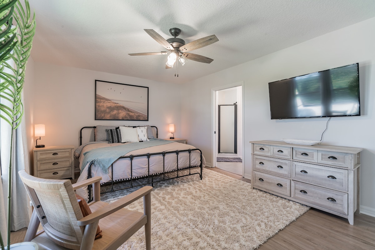 Relájate en la amplia suite principal con cama tamaño king, Smart TV, grandes ventanales para que entre la luz natural y un baño privado con ducha a ras de suelo.